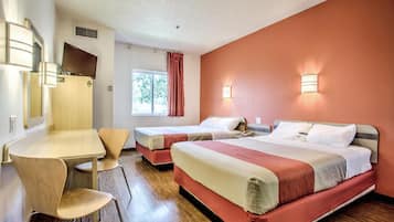 Una habitación de hotel con dos camas, un escritorio y una silla.
