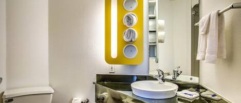 A bathroom with a toilet, sink, and mirror.