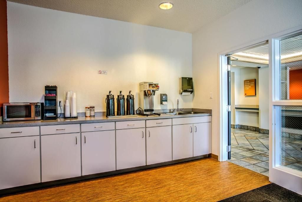 A kitchenette with a microwave, coffee maker, and espresso machine.