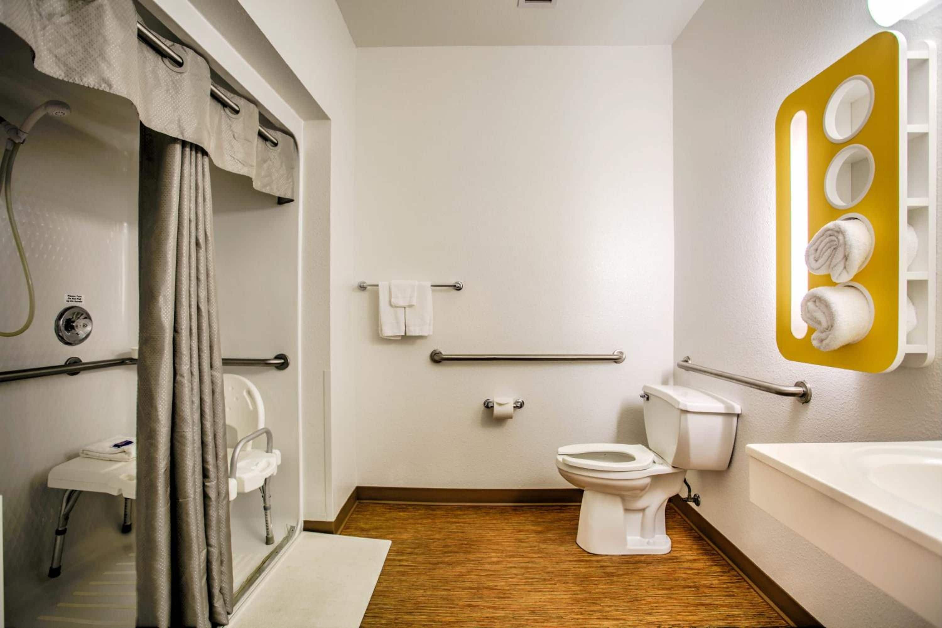 A modern bathroom with a shower, toilet, and bathtub.