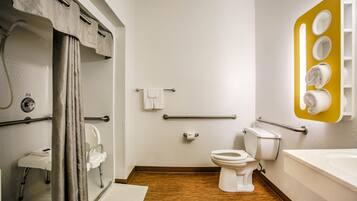A modern bathroom with a shower, toilet, and bathtub.