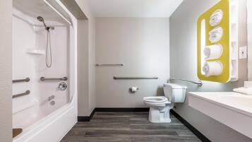A modern bathroom with a bathtub, toilet, and a towel rack.