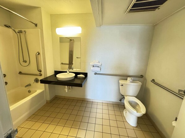 Un baño pequeño y funcional con lavamanos blanco, inodoro y bañera.