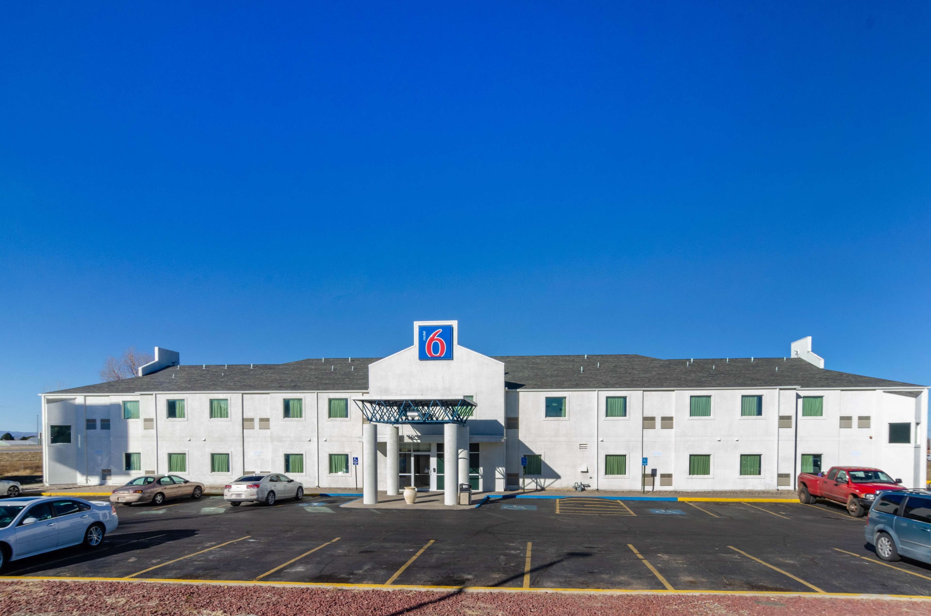 A motel with a large parking lot and a central entrance.