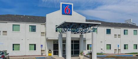 A 6 Motel with a modern design, featuring a covered entrance and accessible parking.