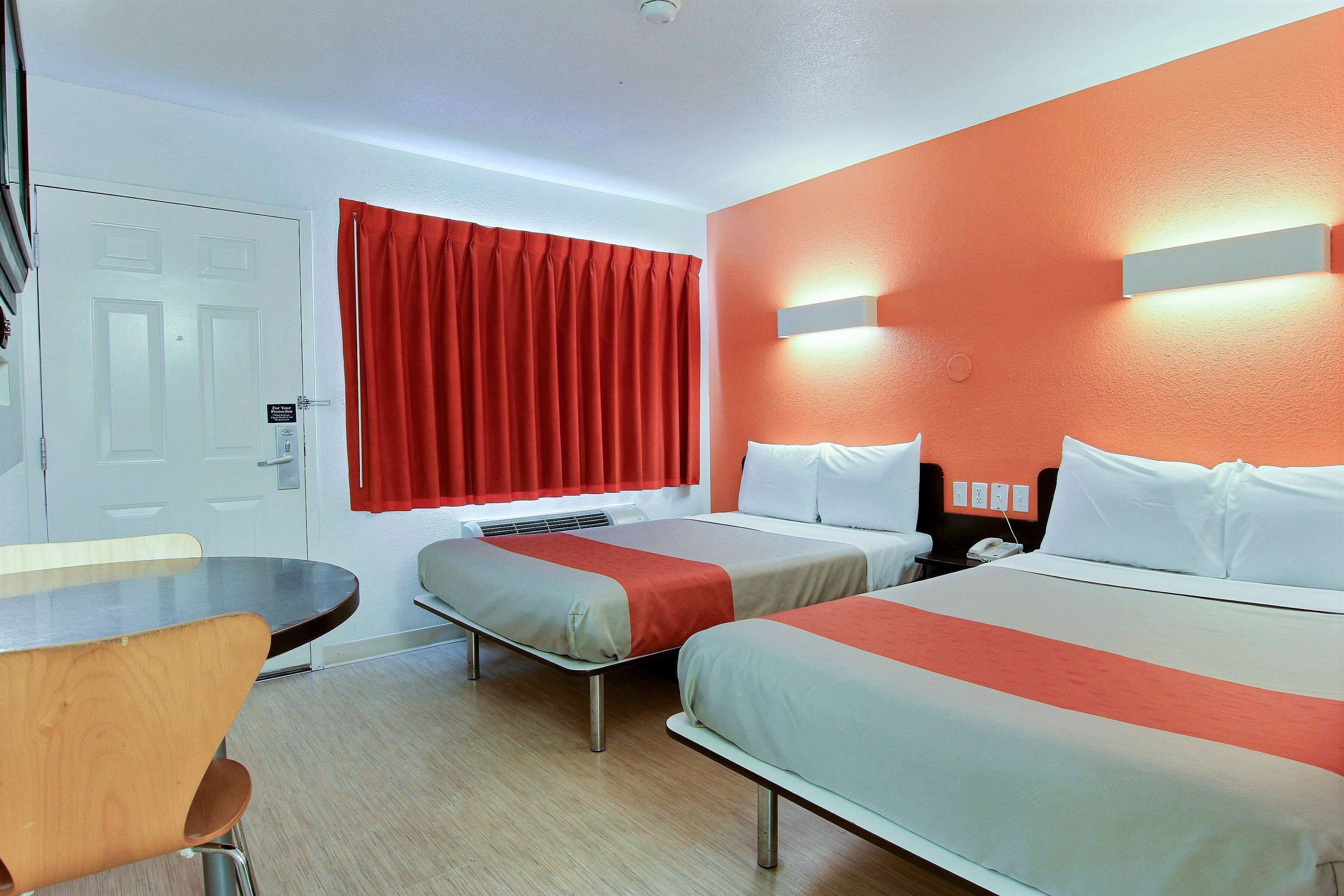 Habitación de hotel con dos camas, un escritorio y una silla.