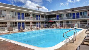 A motel with a swimming pool, multiple balconies, and a U-Haul sign. - Motel 6 Slidell, LA - New Orleans (Slidell)