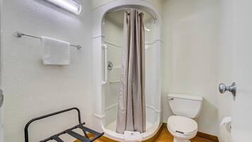 Een bad/douchecombinatie, handdoeken, zeep, shampoo