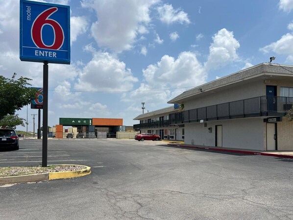 A motel with a '6 ENTER' sign, a parking lot, and a building with an 'Office' sign. - Motel 6 Odessa, TX (Odessa)