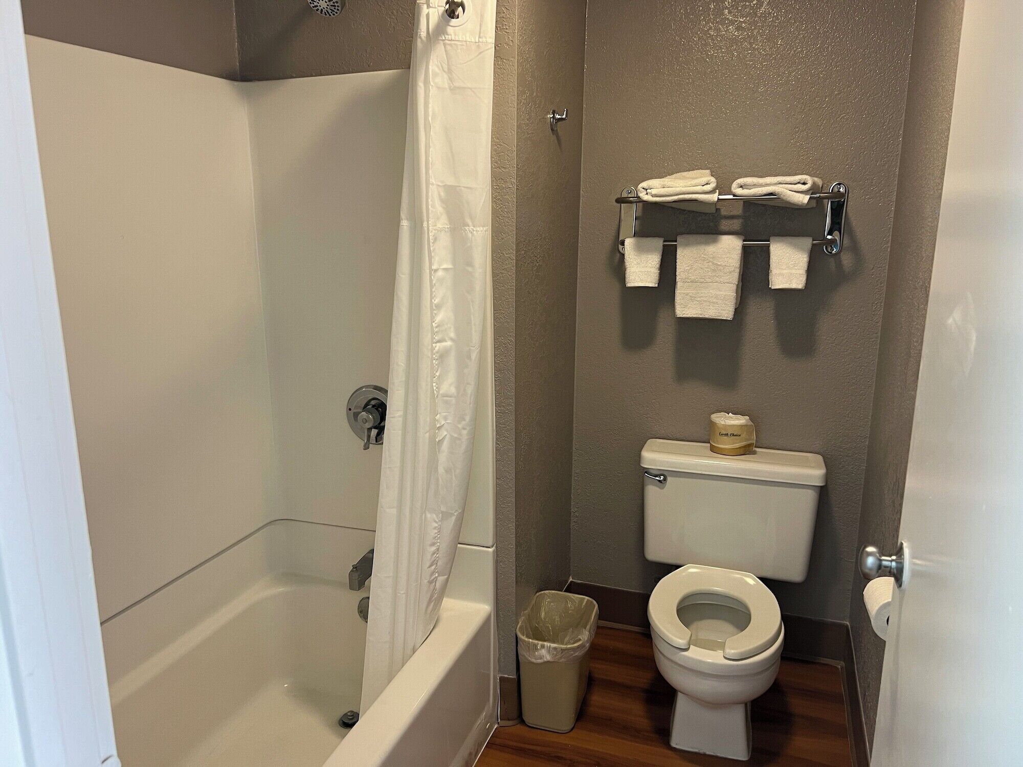 Un baño con bañera, inodoro y cortina de ducha.
