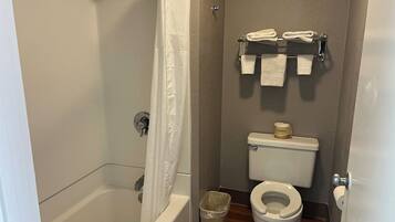 Un baño con bañera, inodoro y cortina de ducha.