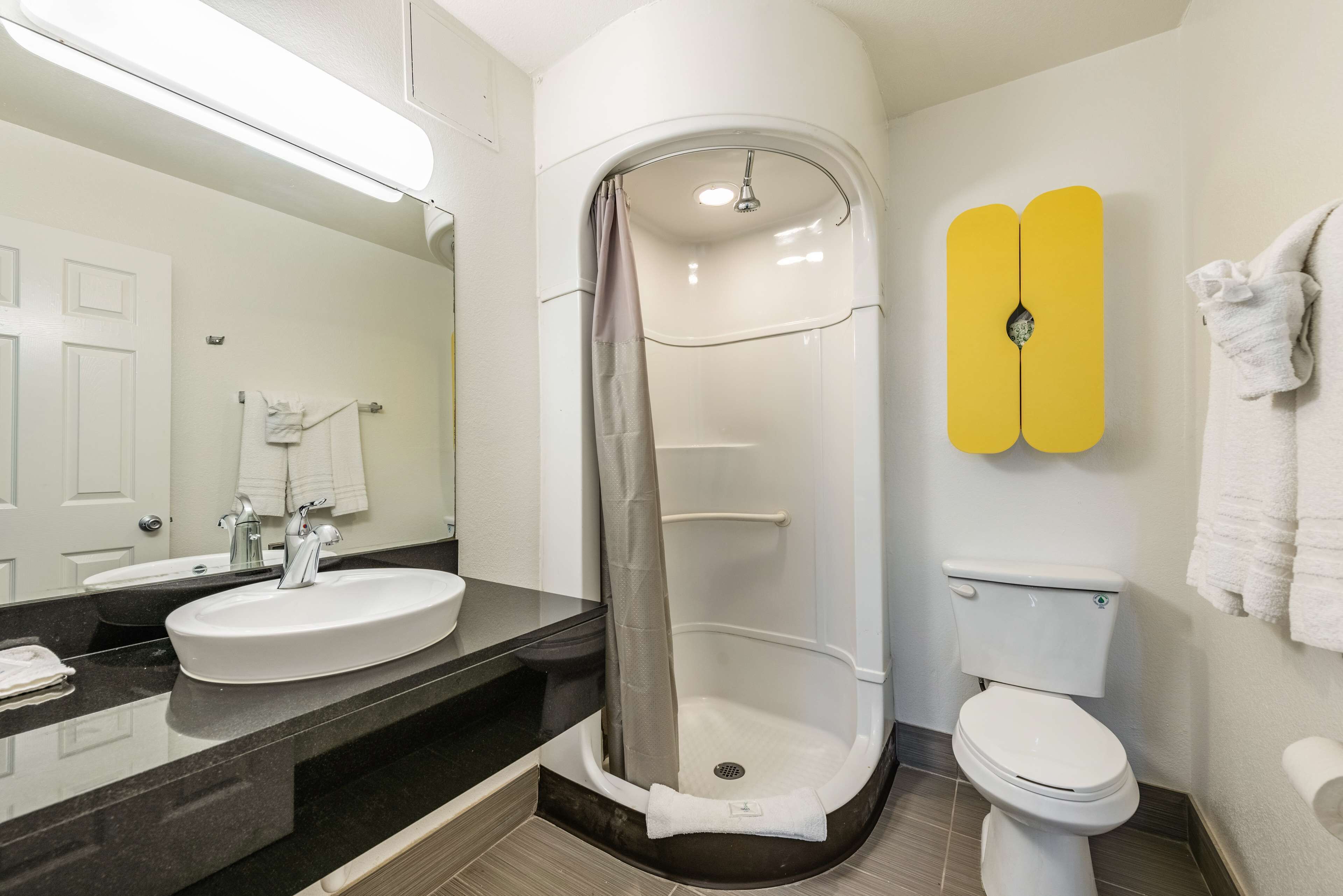 Un baño con lavamanos blanco, inodoro y cabina de ducha.
