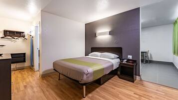 Una camera da letto moderna con un letto, un comodino e una scrivania.