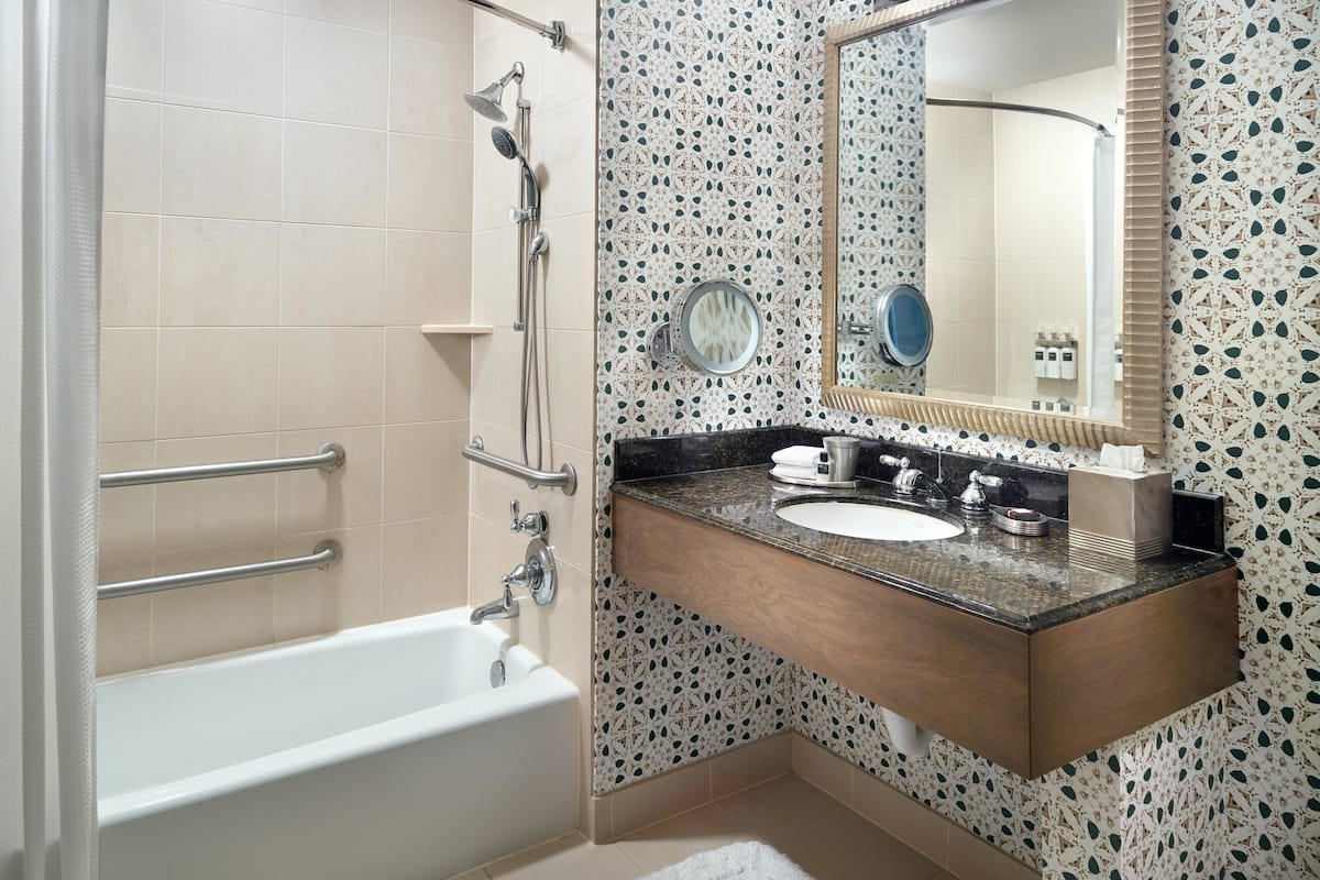 Une salle de bain avec une baignoire, un lavabo avec un miroir et une douche.