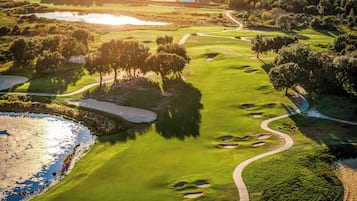 A golf course with bunkers, water hazards, and a winding path.