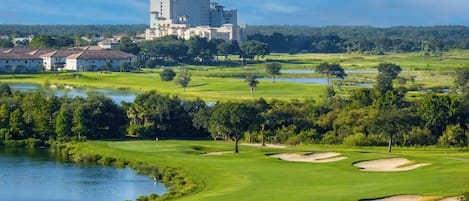 A golf course with a large building in the background.
