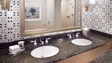 A bathroom with two sinks, a large mirror, and patterned walls.