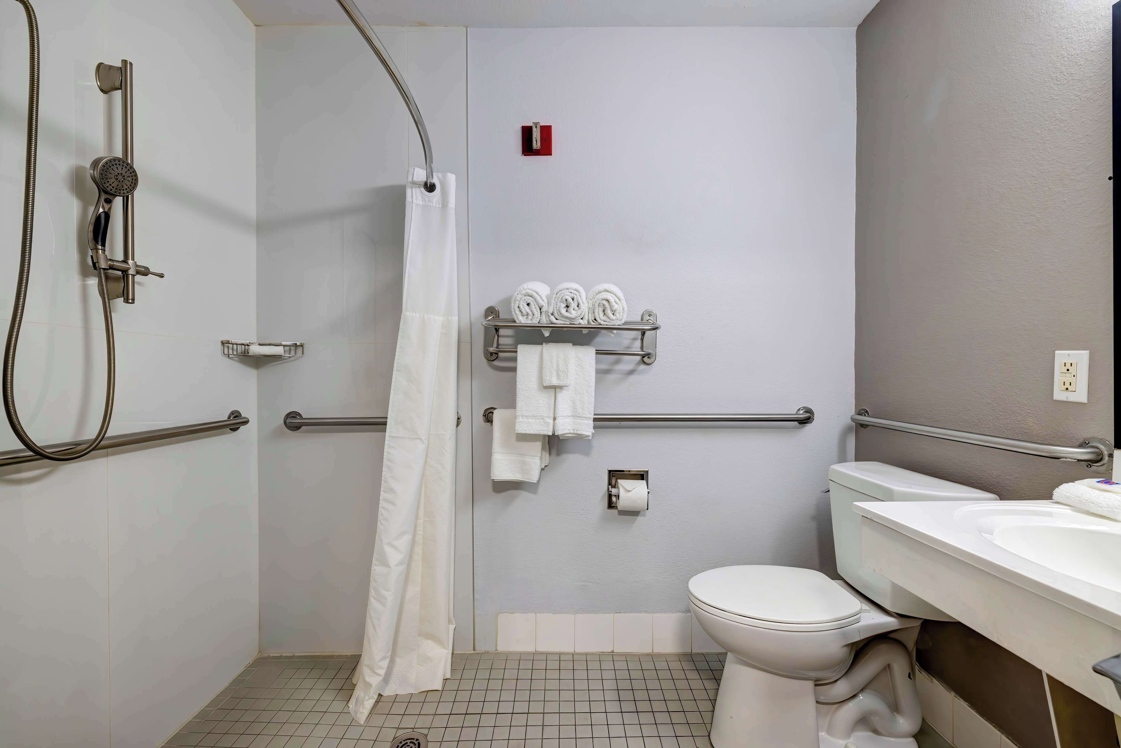 A bathroom with a shower, toilet, and sink.