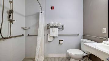 A bathroom with a shower, toilet, and sink.