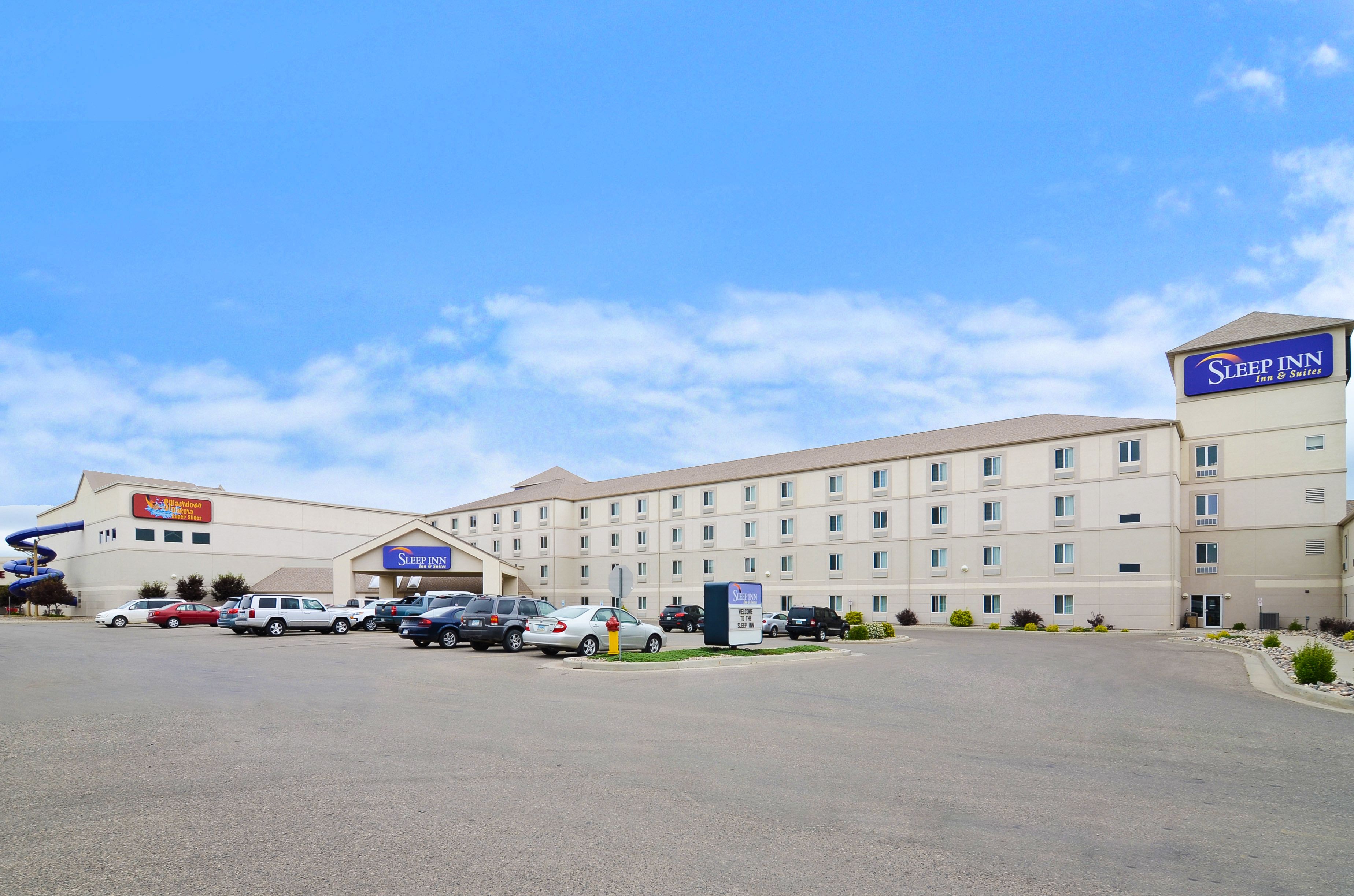 A Sleep Inn hotel with a parking lot and several cars.