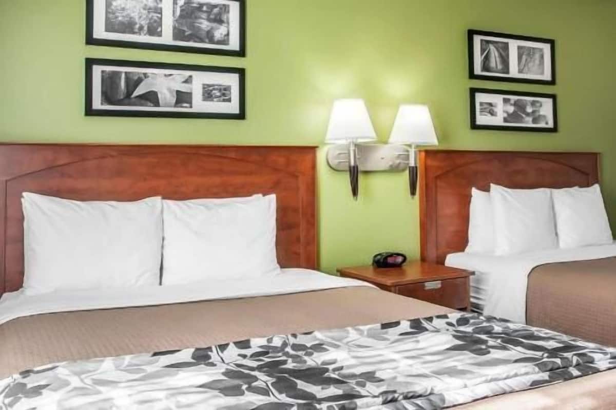 A hotel room with a bed, a nightstand, and wall-mounted lamps.