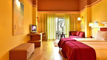 A hotel room with two beds, a desk, a chair, and a small table.