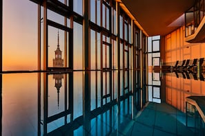 A corridor with reflective floors and large windows, leading to a seating area with chairs. - InterContinental Warsaw by IHG (Warsaw)