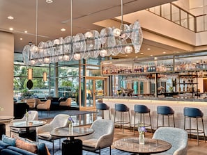 A modern bar area with seating and a view of the street.