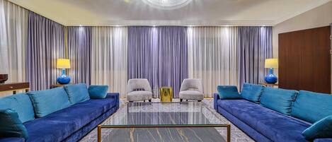 A modern living room with two sofas, a coffee table, and a chandelier.
