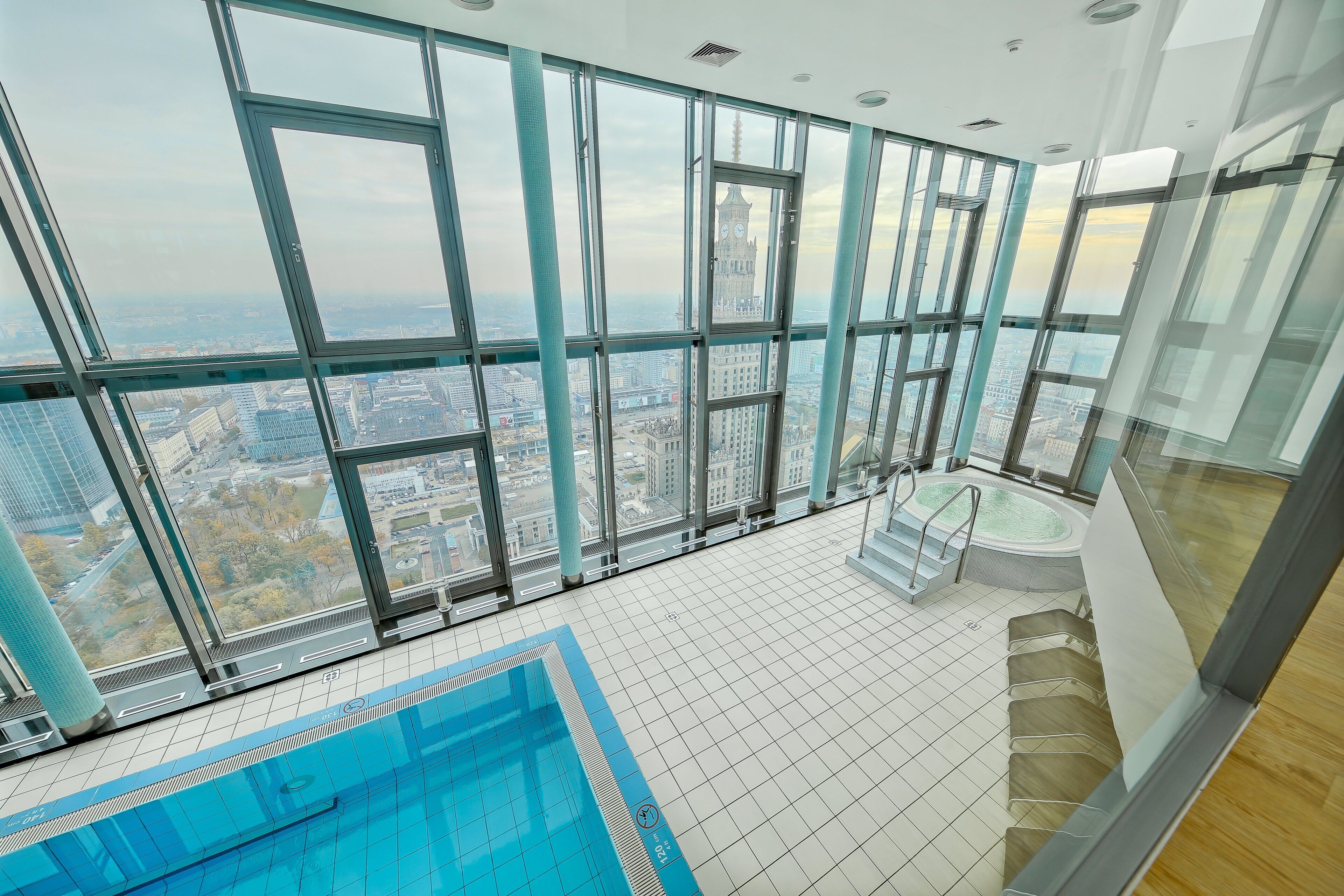 A high-rise building with a large indoor swimming pool and panoramic city views.