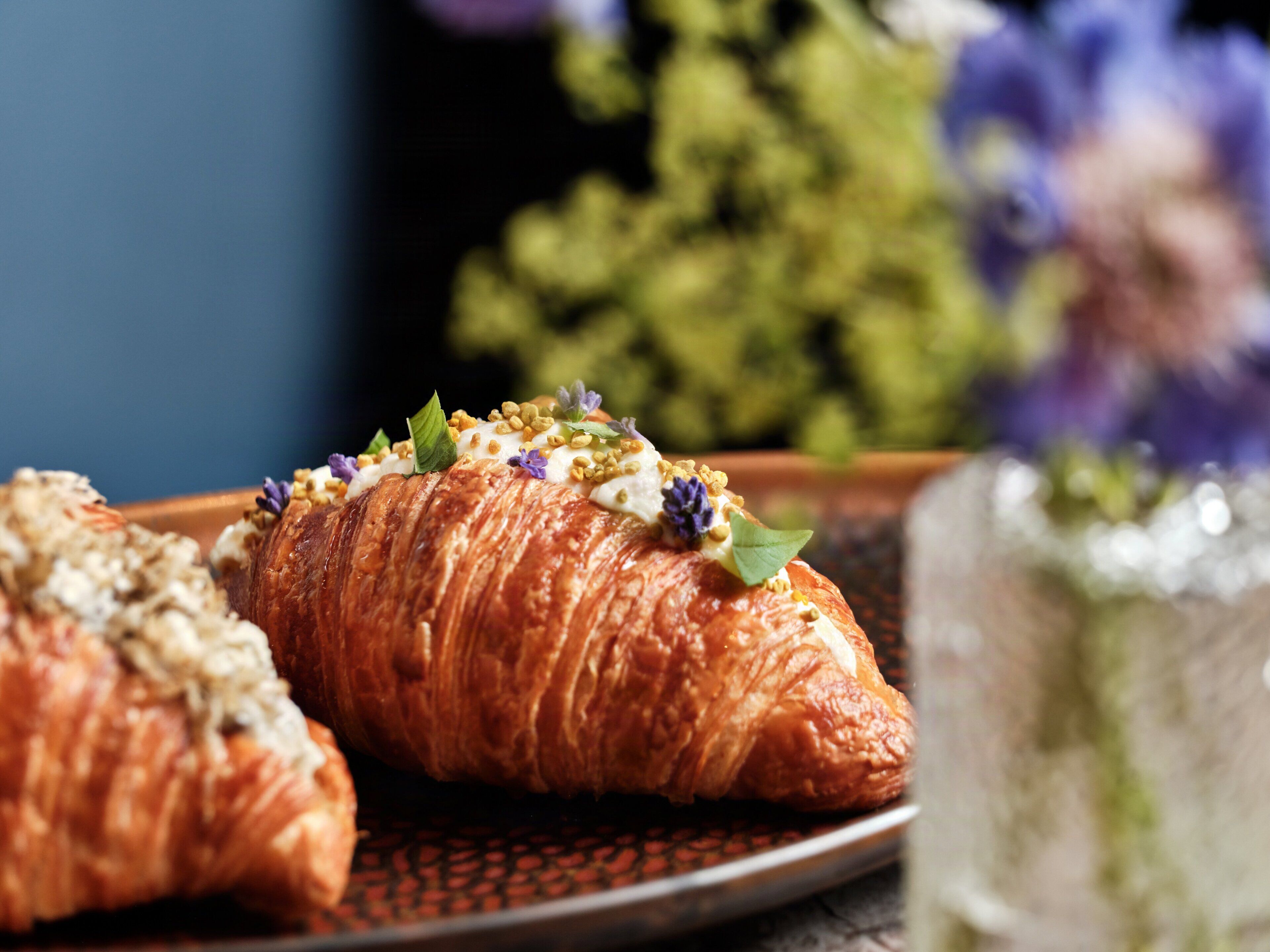 A plate with two croissants and a glass of water.