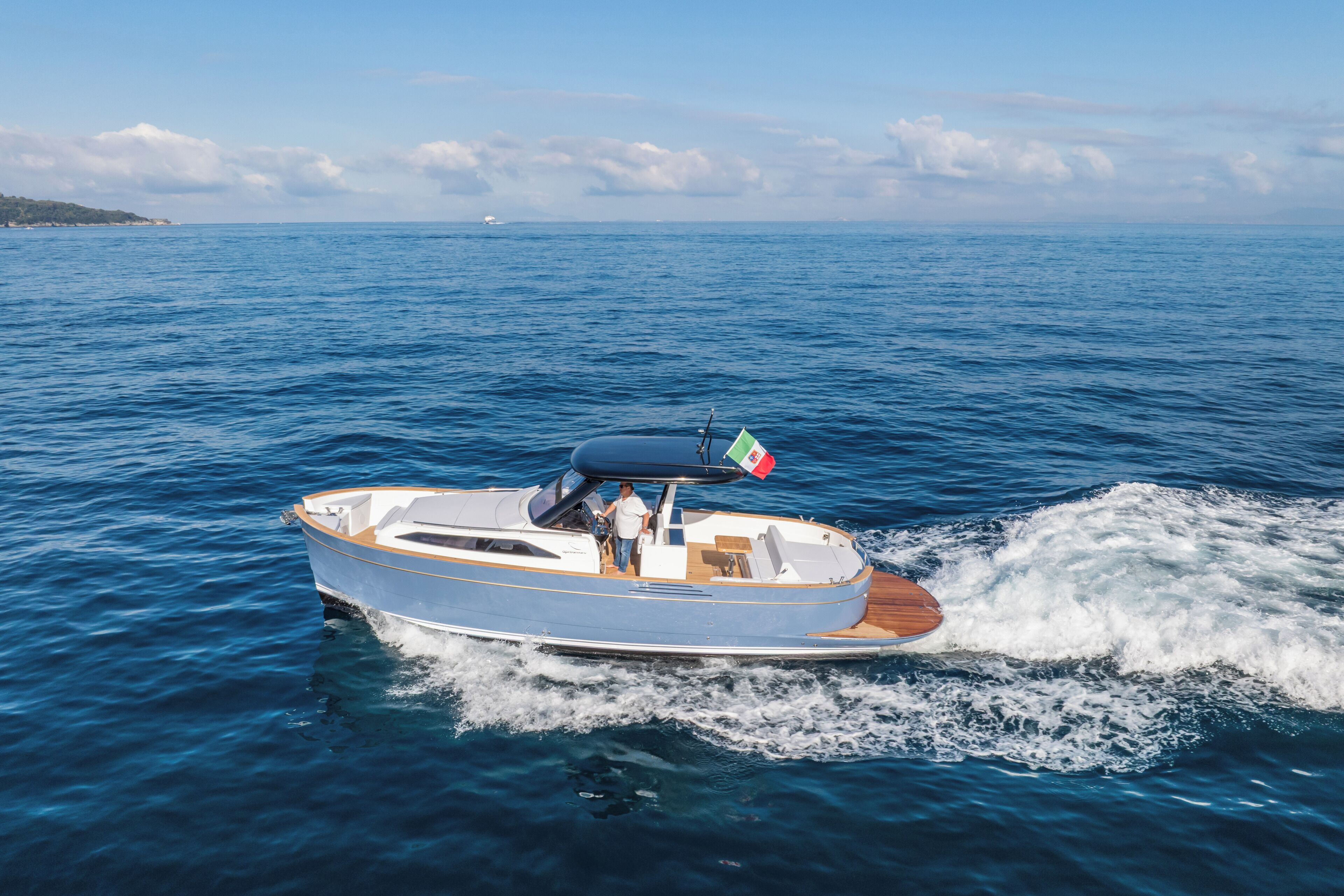 A motorboat on a calm sea with a clear sky.