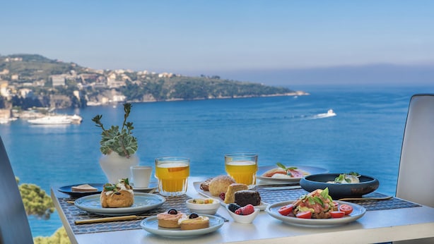 A table with breakfast items and a view of the sea. - Hotel Mediterraneo (Sant'Agnello)