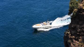 A boat on a body of water near a rocky coastline.