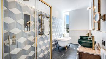 Un bagno moderno con una vasca freestanding, una doccia con pareti in vetro e un mobile lavabo con lavabo verde.