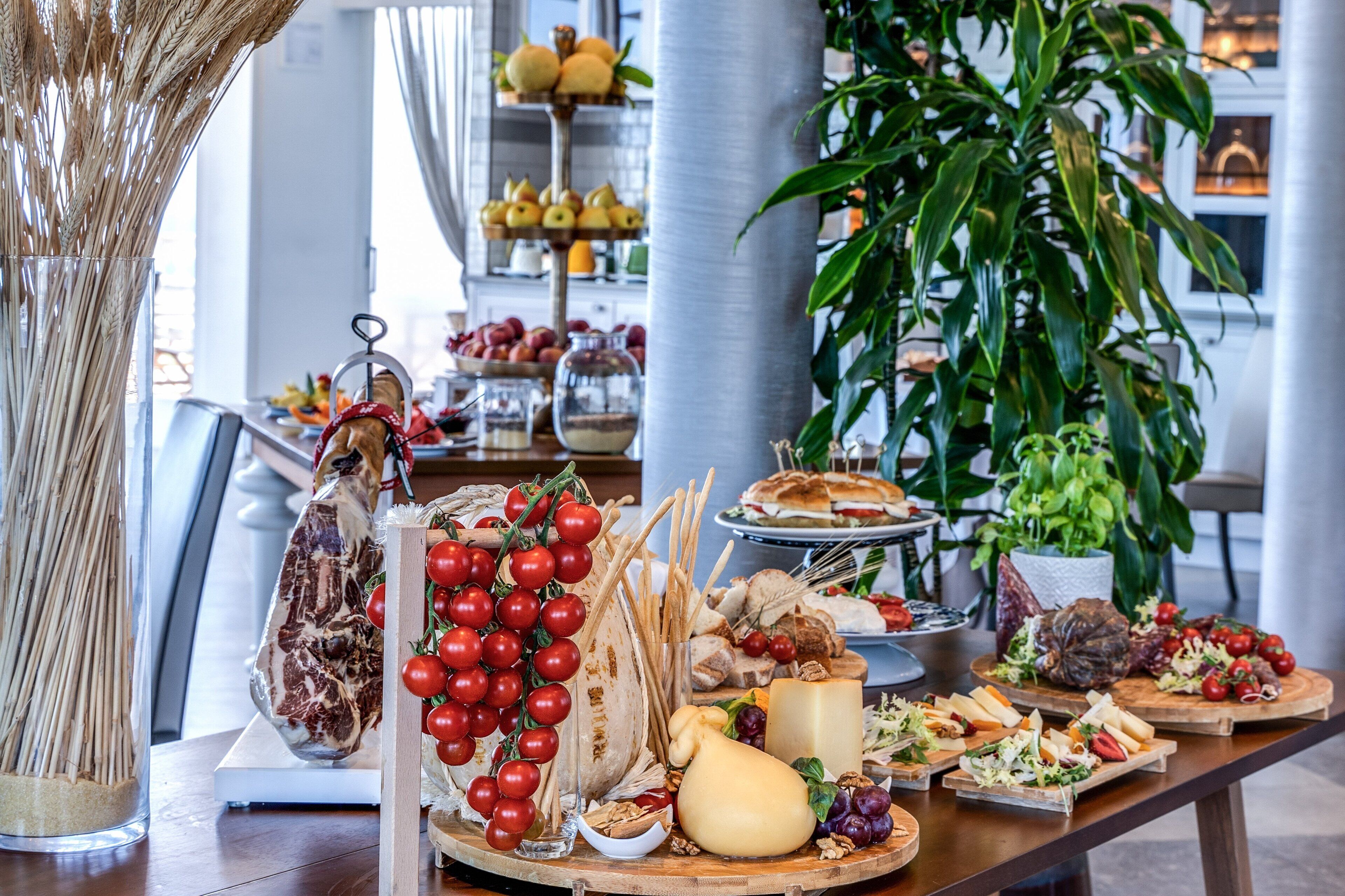 Un tavolo del buffet con diversi cibi, tra cui formaggi, salumi e frutta.