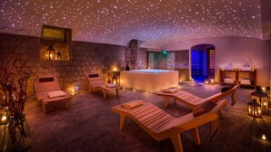 A spa with wooden loungers, a hot tub, and ambient lighting. - Hotel Mediterraneo (Sant'Agnello)