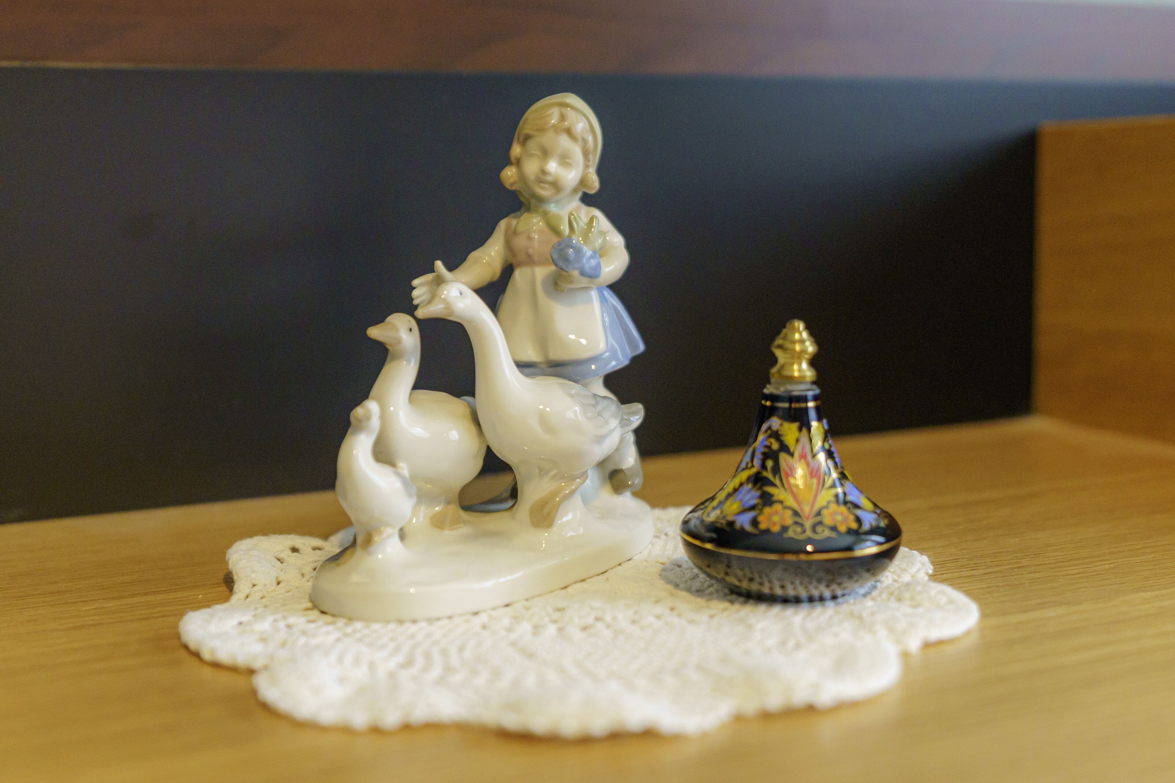 Eine Figur eines Kindes mit einer Gans auf einer Tischdecke.