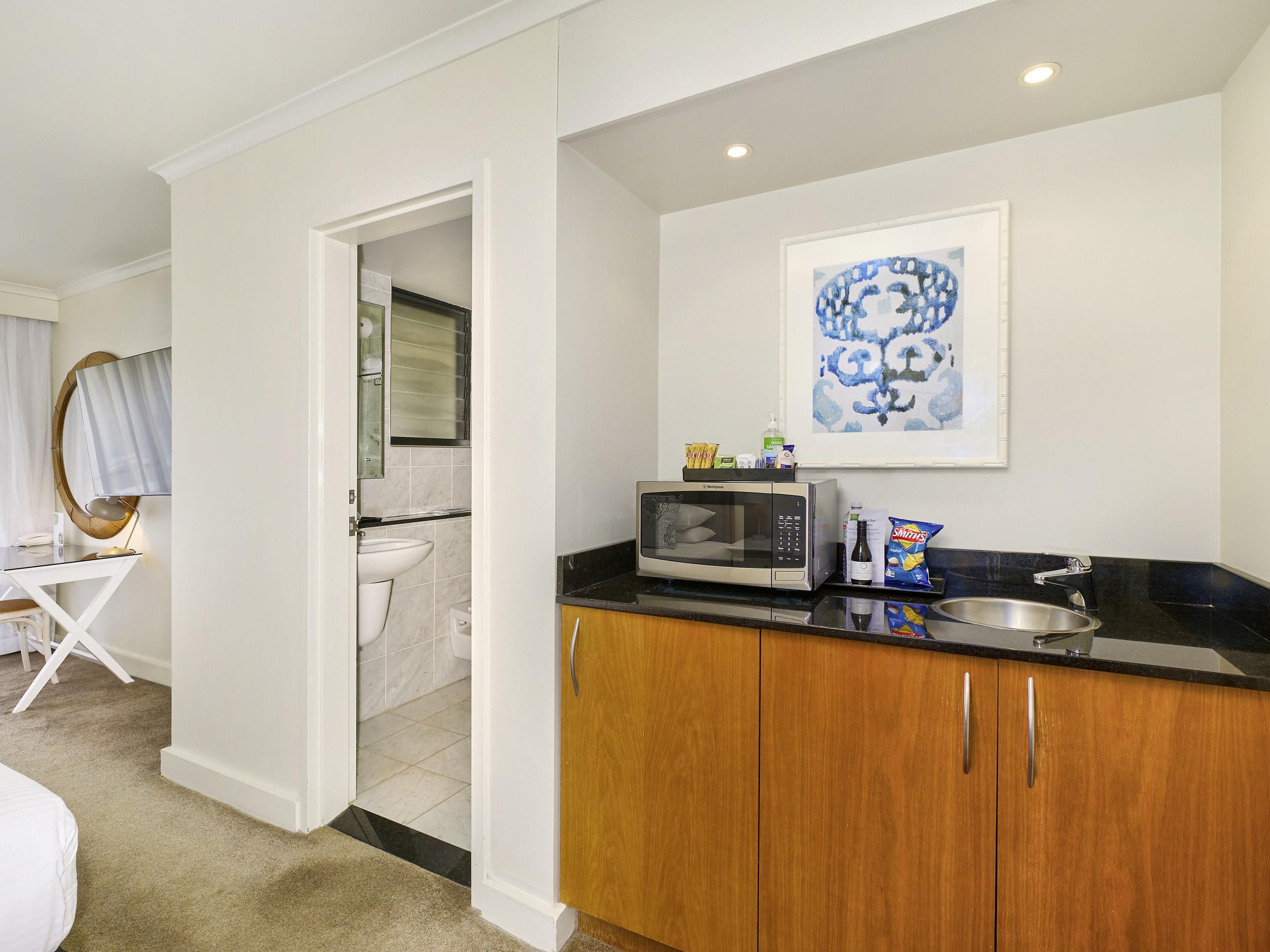 A modern kitchen with a microwave, sink, and countertop.