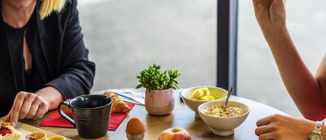 Una mesa de desayuno con un plato de comida, una taza y un bol.