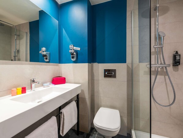 A modern bathroom with a white sink, a glass shower enclosure, and a toilet. - ibis Nuits Saint Georges (Nuits-Saint-Georges)