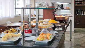 A buffet with various food items and a coffee station. - Triângulo Apart Hotel (Vitoria)