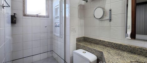 A bathroom with a shower, toilet, and sink.