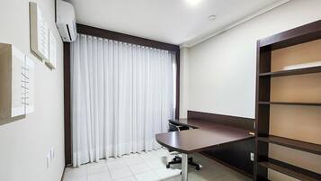 Un pequeño espacio de oficina moderno con un escritorio, una silla y estanterías.