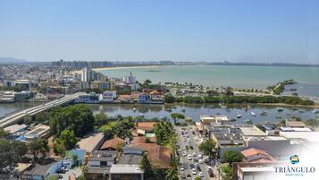 A coastal cityscape with a marina, buildings, and a beach.