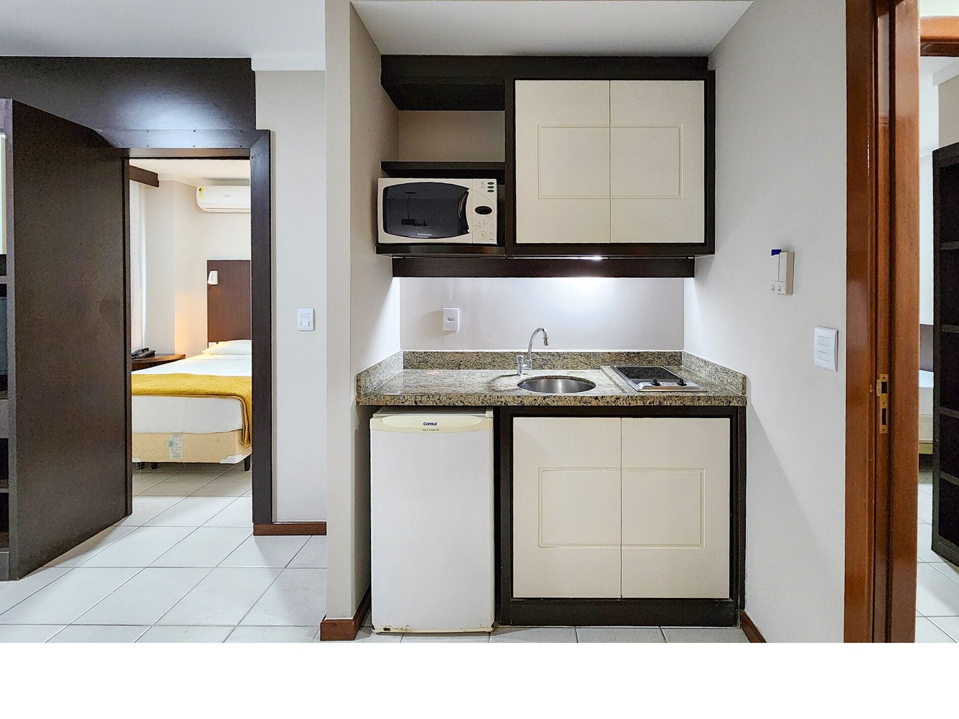 A compact kitchenette with a microwave, sink, and small refrigerator.