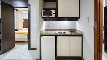 A compact kitchenette with a microwave, sink, and small refrigerator.