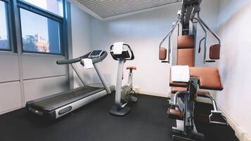 A gym with a treadmill, elliptical, and a rowing machine.