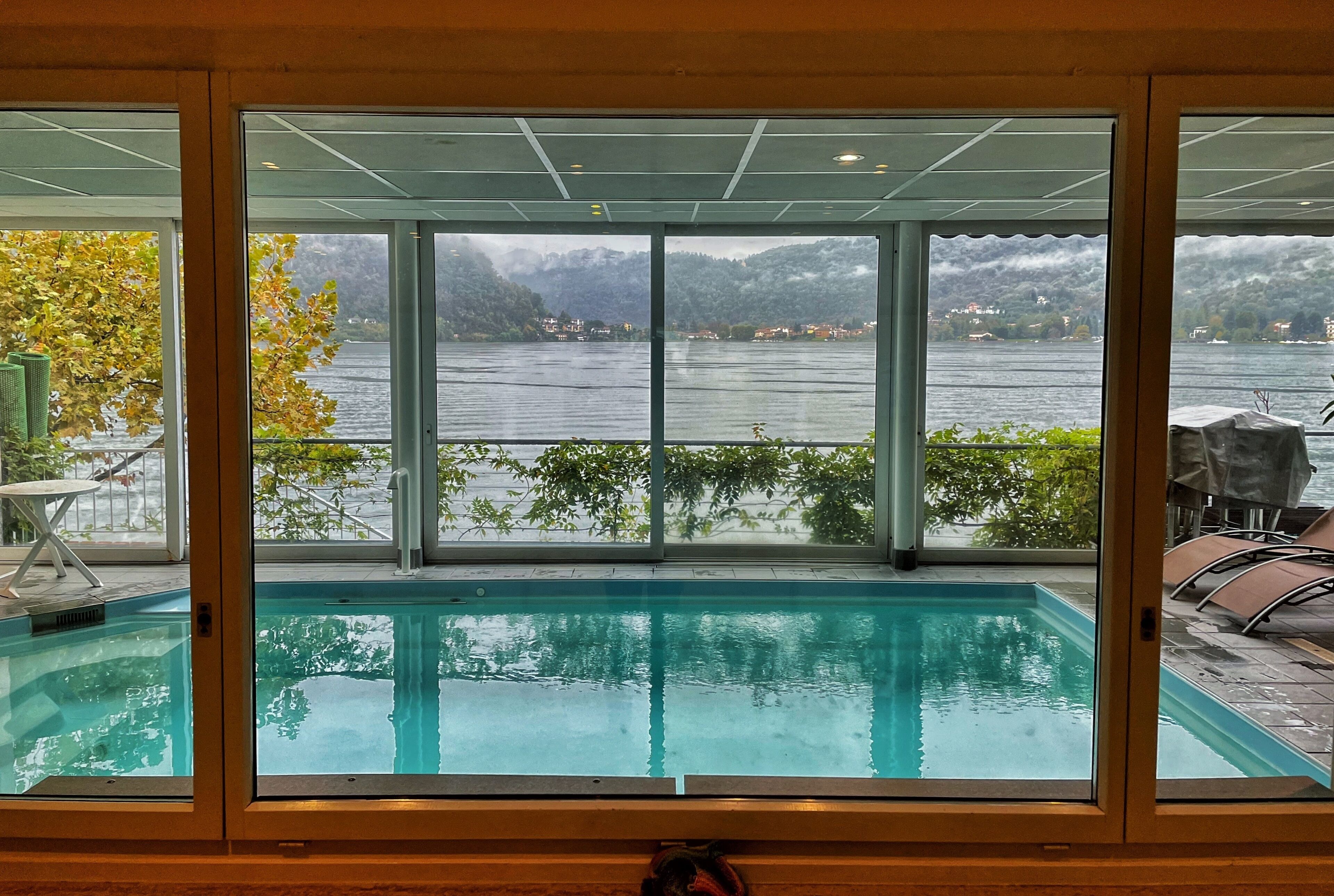 A swimming pool with a view of a lake and mountains.