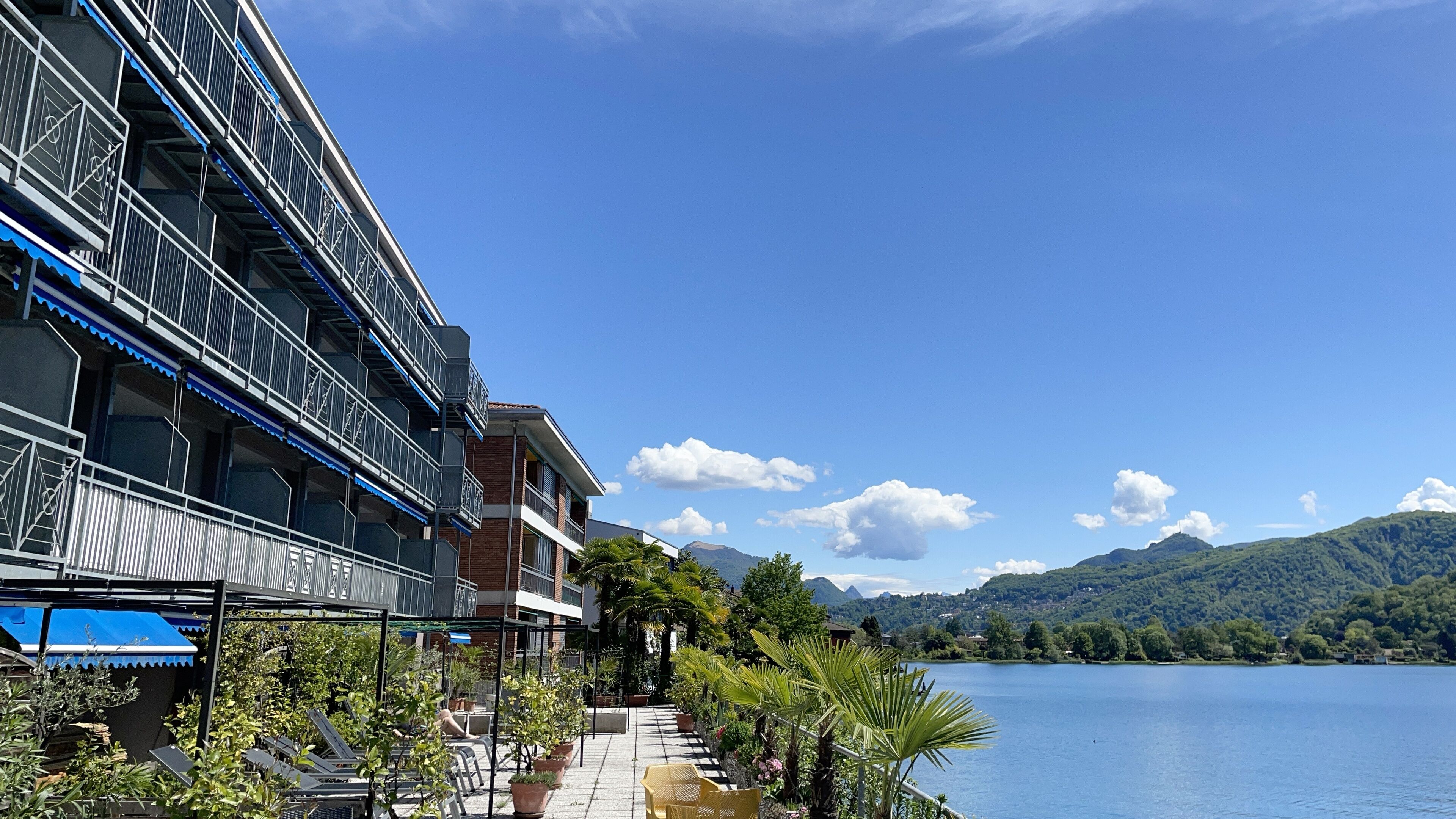 Ein Hotel mit Außenbereich und Blick auf einen See und Berge.